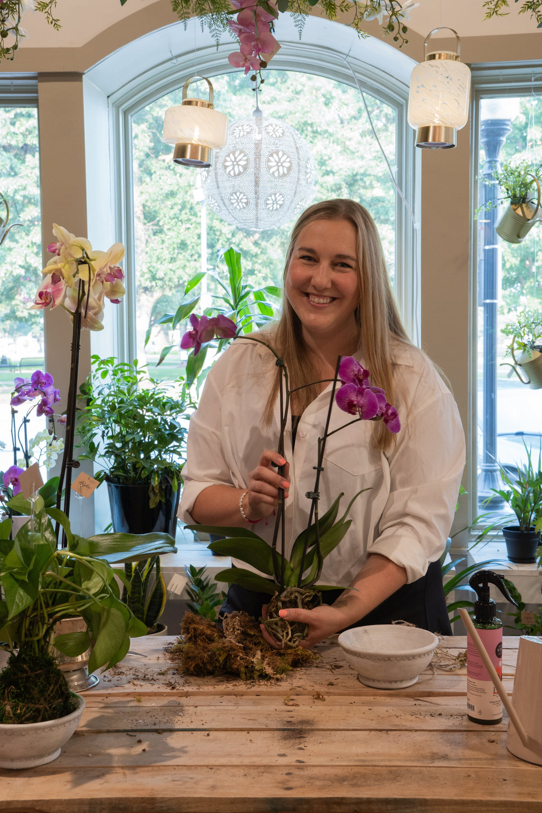 Alie Muller-Heit, owner of Thistles Flower Market, planting an orchid in Pella, Iowa