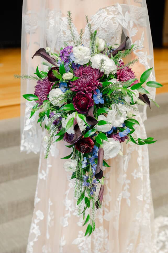 Cascading bridal bouquet with purple, white, and blue flowers, Pella, Iowa