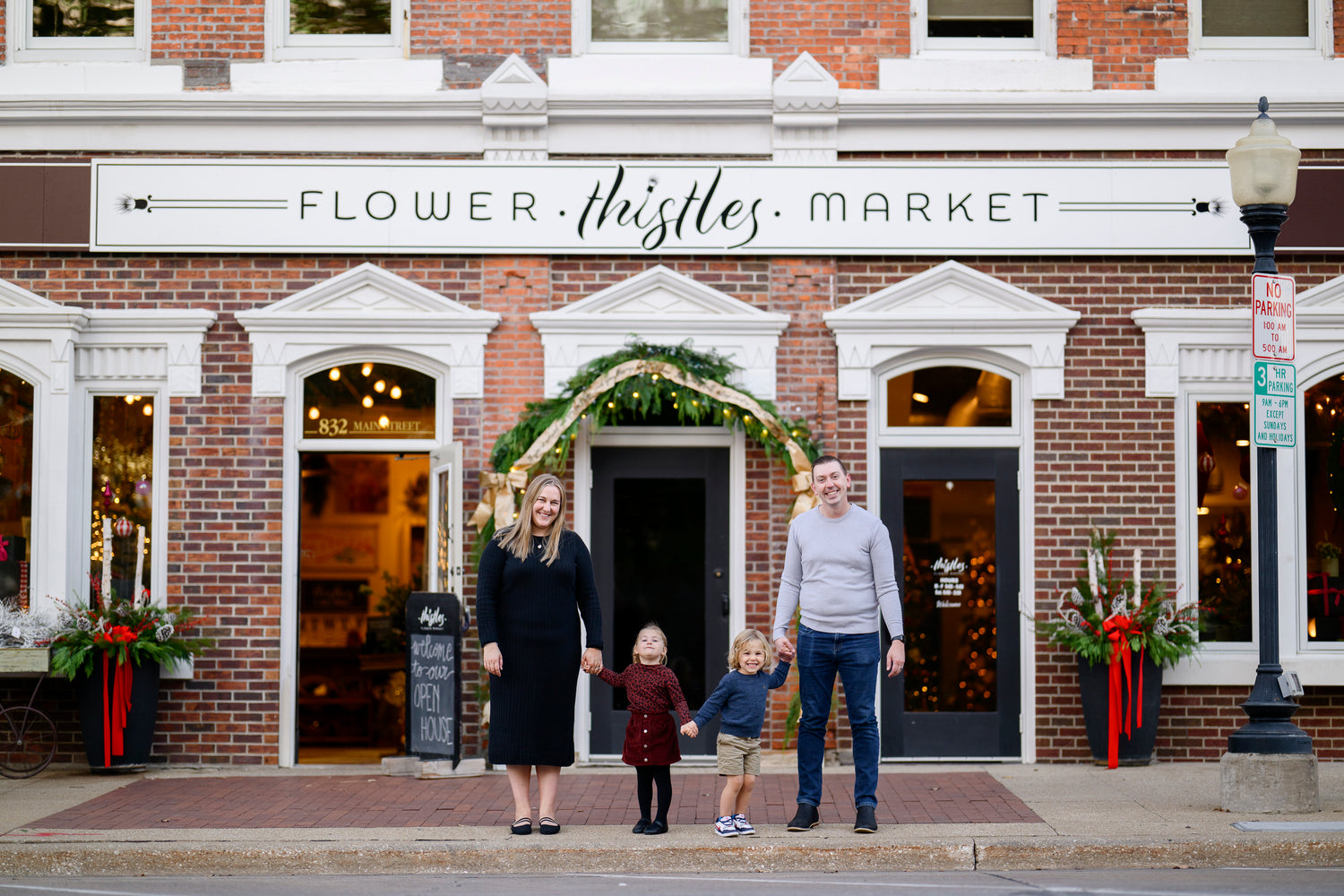 Alie Muller-Heit with her husband and children in front of Thistles Flower Market on the day they purchased the shop in Pella, Iowa. 