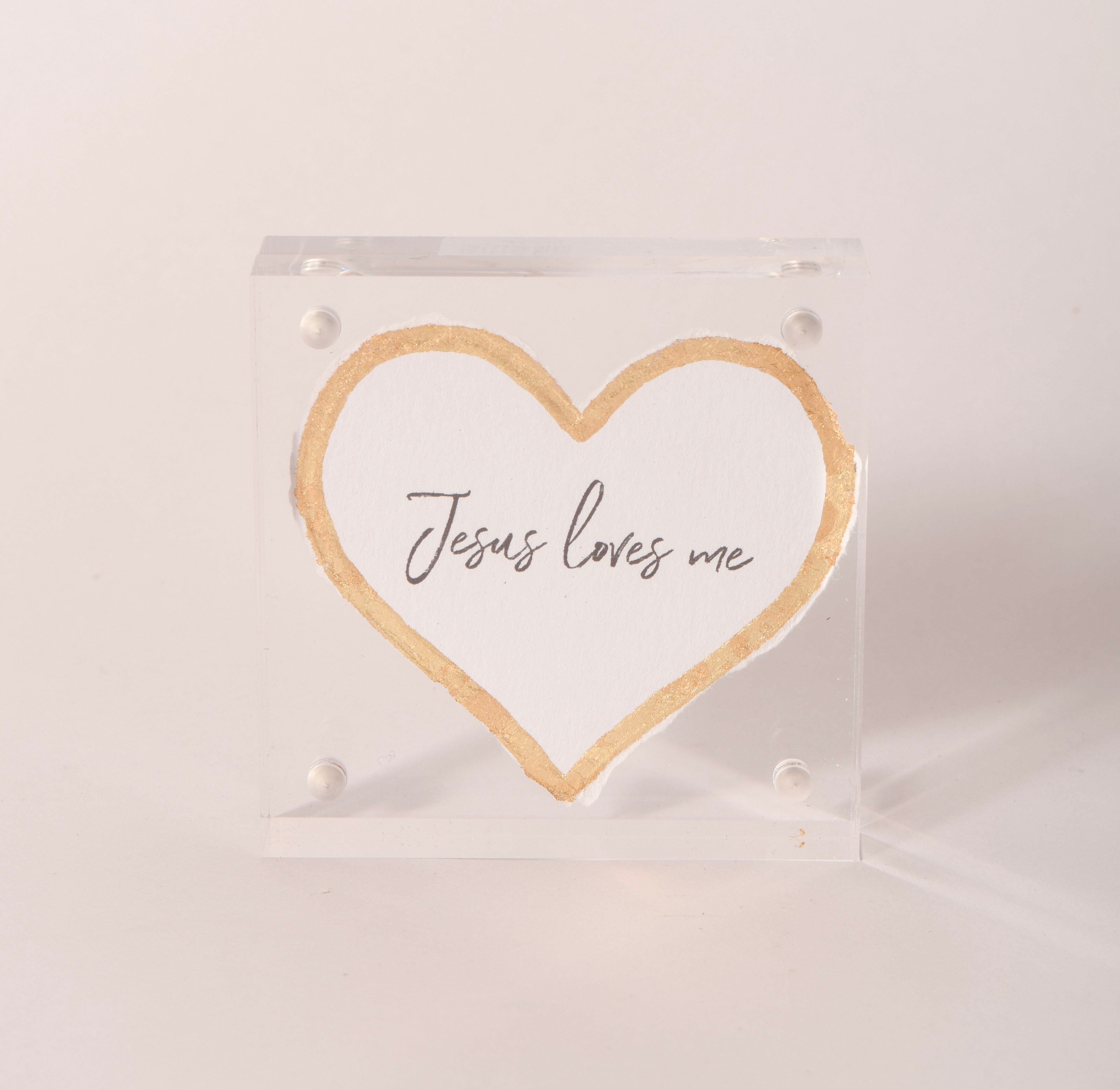 Clear acrylic keepsake with a gold-embossed "Jesus Loves Me" heart, sold at Thistles in Pella, Iowa